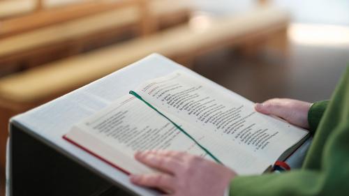 Ein Pfarrer liest die Frohe Botschaft am Ambo