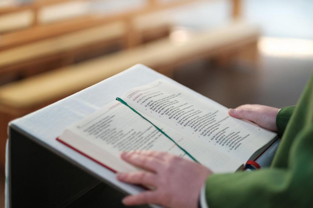 Ein Pfarrer liest die Frohe Botschaft am Ambo